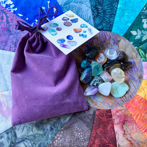 A bag of sixteen stones collection of crystal gemstones sitting on a sacred space quilted wheel. 